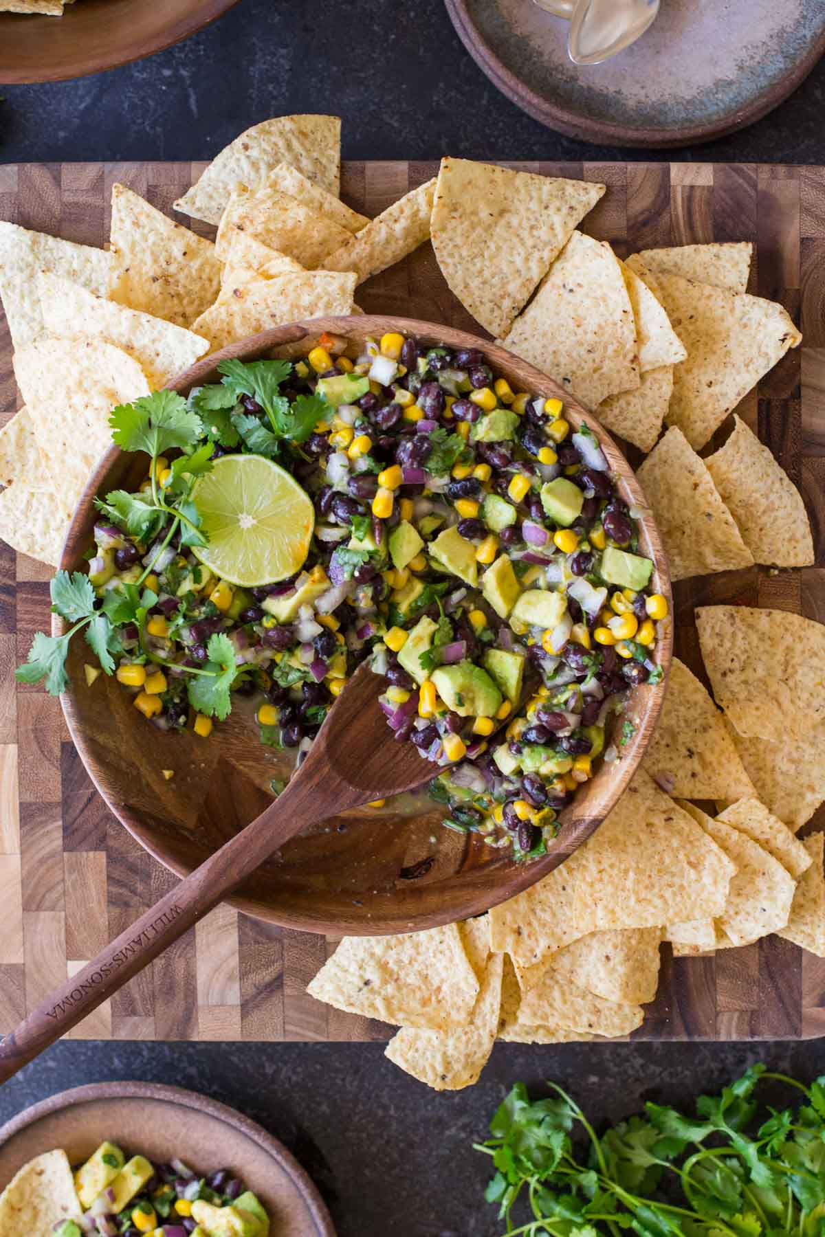 Quick and easy Avocado Dip in a bowl surrounded by tortilla chips.  