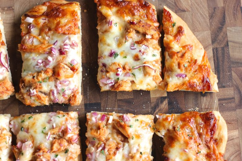 BBQ Chicken Pizza sliced on a cutting board.  