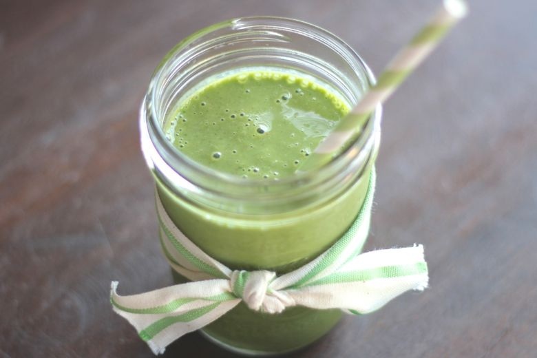 Green Smoothie in a glass jar with a drinking straw.  