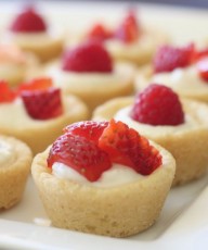 Sugar cookie tarts filled with sweetened cream cheese and topped with berries.