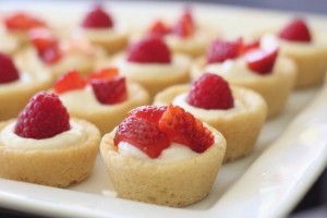 Sugar cookie tarts filled with sweetened cream cheese and topped with berries.