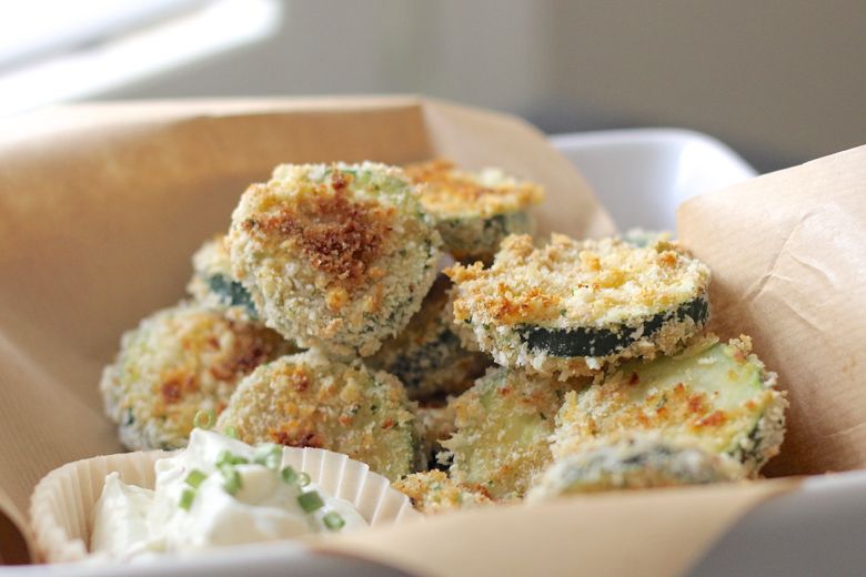 Baked Zucchini stacked in a bowl with Skinny Buttermilk Ranch next to it.  