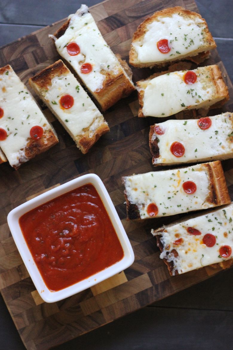 Whole Wheat Garlic Bread Pizza sliced on a cutting board with marinara in a cup.  