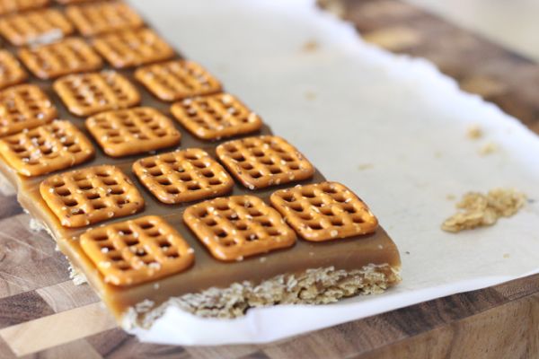 Salted Caramel Oat Bars on parchment paper on a cutting board. 