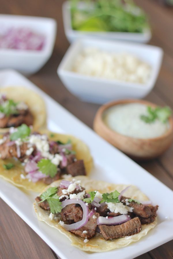 Grilled steak, red onions, and queso fresco on a lightly fried white corn tortilla.