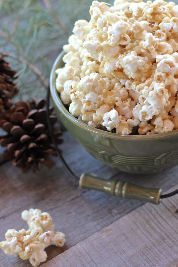 No Bake Caramel Corn in a bowl with a few pieces on a board.  