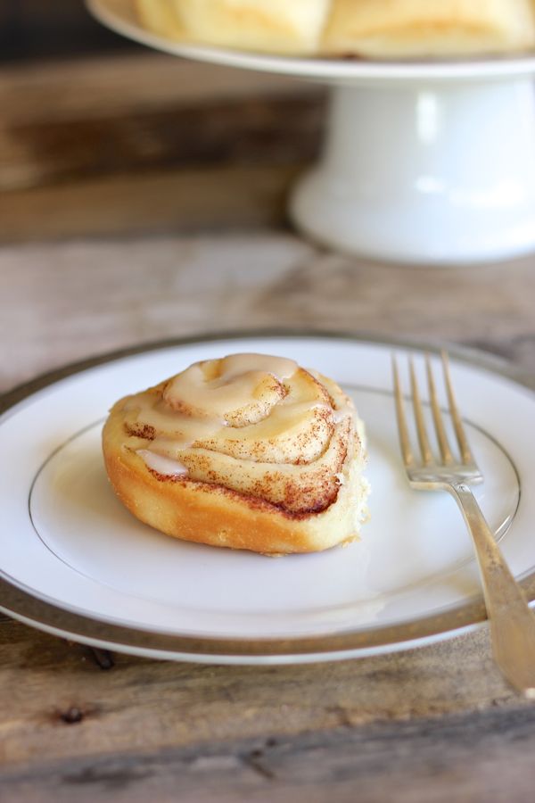 Maple Glazed Cinnamon Roll on a plate with a fork.  