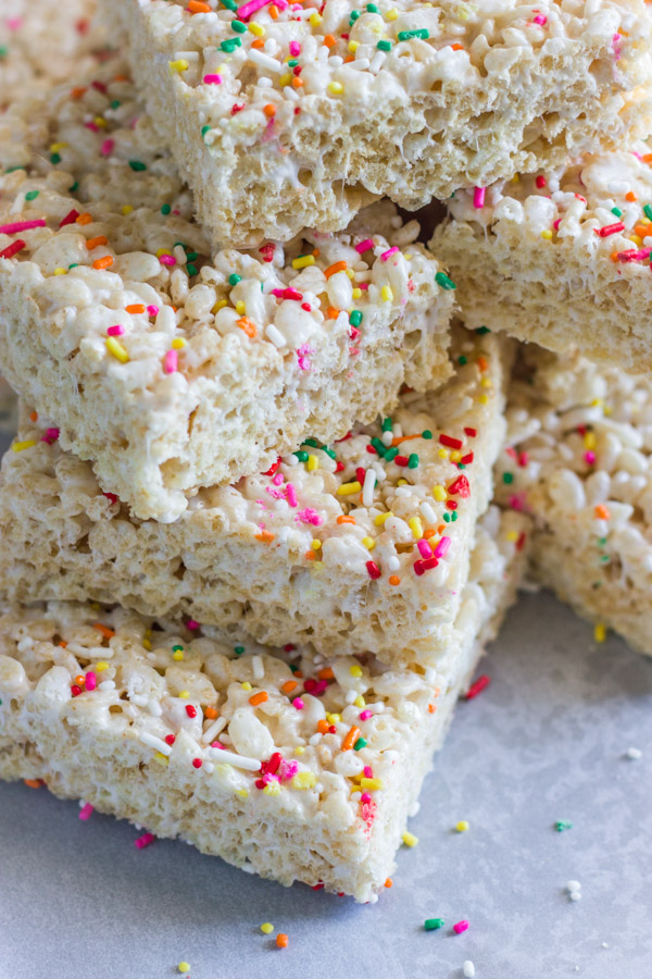 Coconut Oil Rice Krispie Treat squares with sprinkles stacked in a pile.