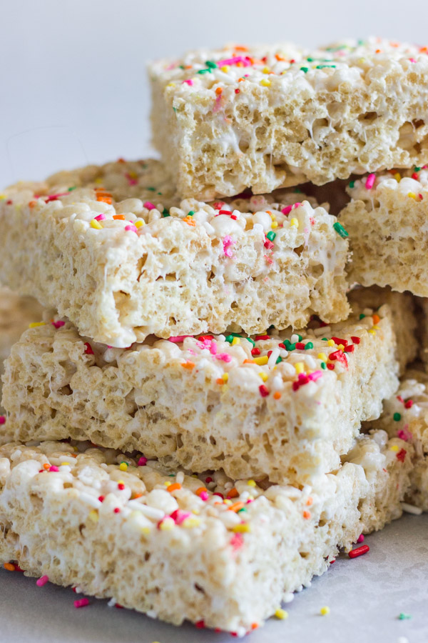 Coconut Oil Rice Krispie Treat squares with sprinkles stacked in a pile.