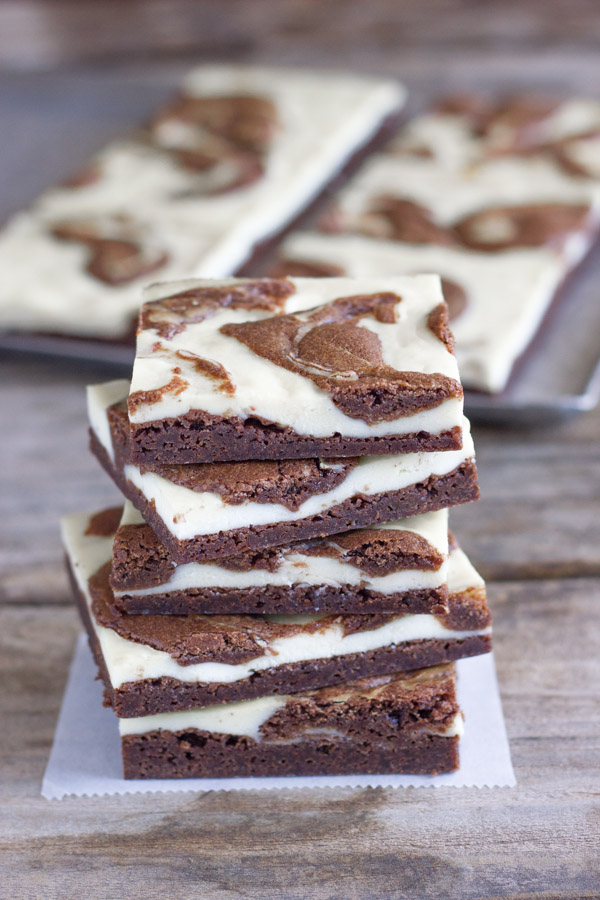 Cheesecake Swirled Fudge Brownies cut in squares and stacked in a pile of five.