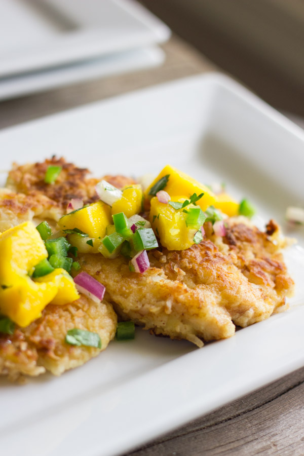 Coconut Crusted Chicken With Mango Salsa on top, on a plate.  