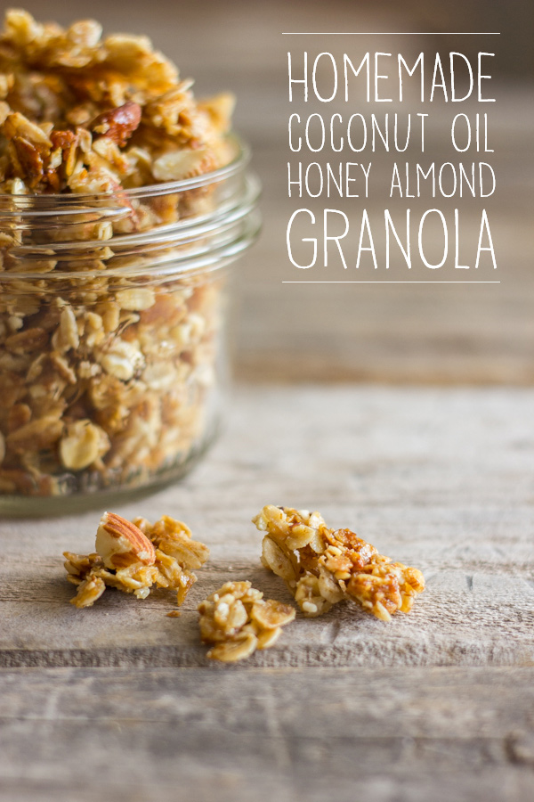 Homemade Coconut Oil Honey Almond Granola in a small glass jar with a few chunks spilled out next to it. 