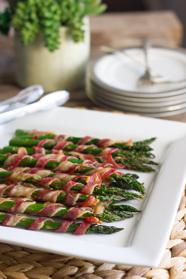 A plate of bacon wrapped asparagus on a Thanksgiving table. 