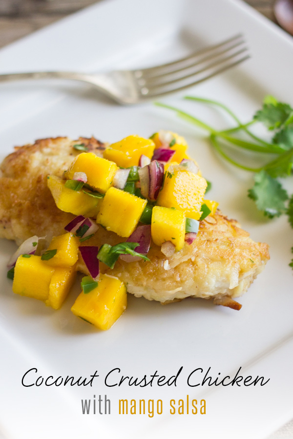 Coconut Crusted Chicken With Mango Salsa on top, on a plate with a fork and cilantro.  