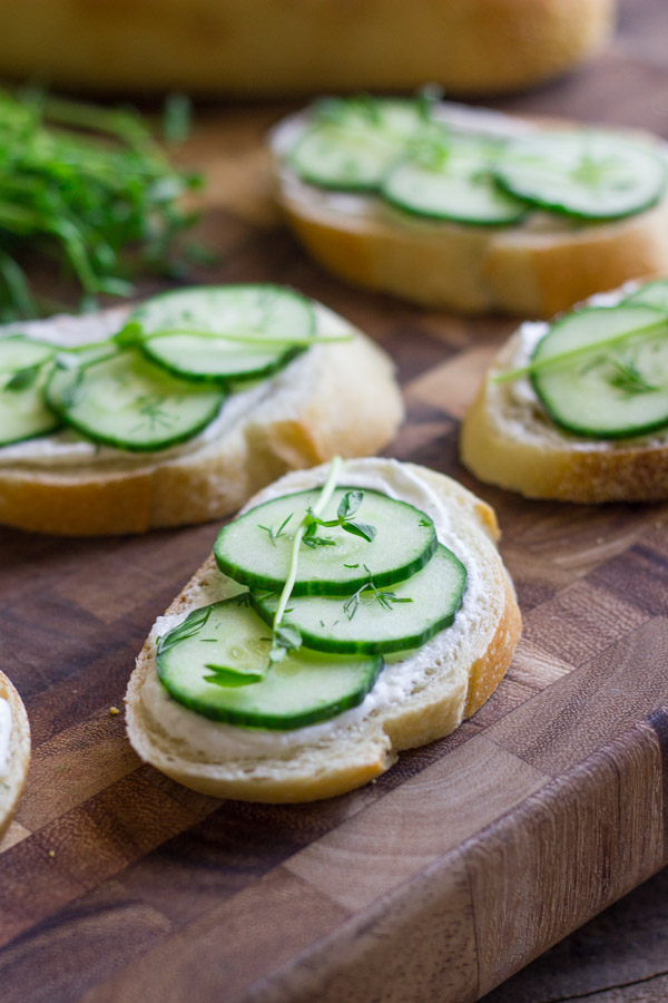 Cucumber Sandwiches With Whipped Goat Cheese on a cutting board.