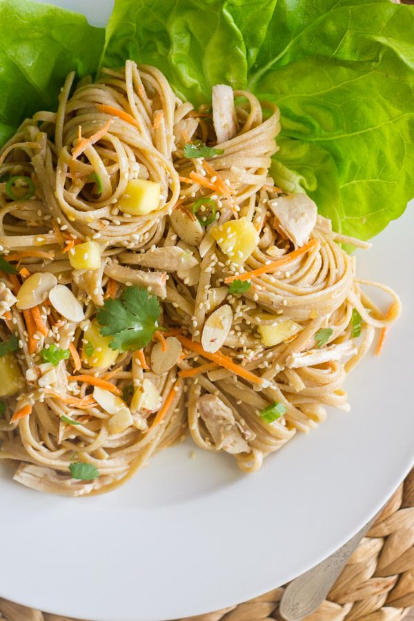 Asian Chicken And Sesame Noodle Salad on a plate with butter lettuce leaves.