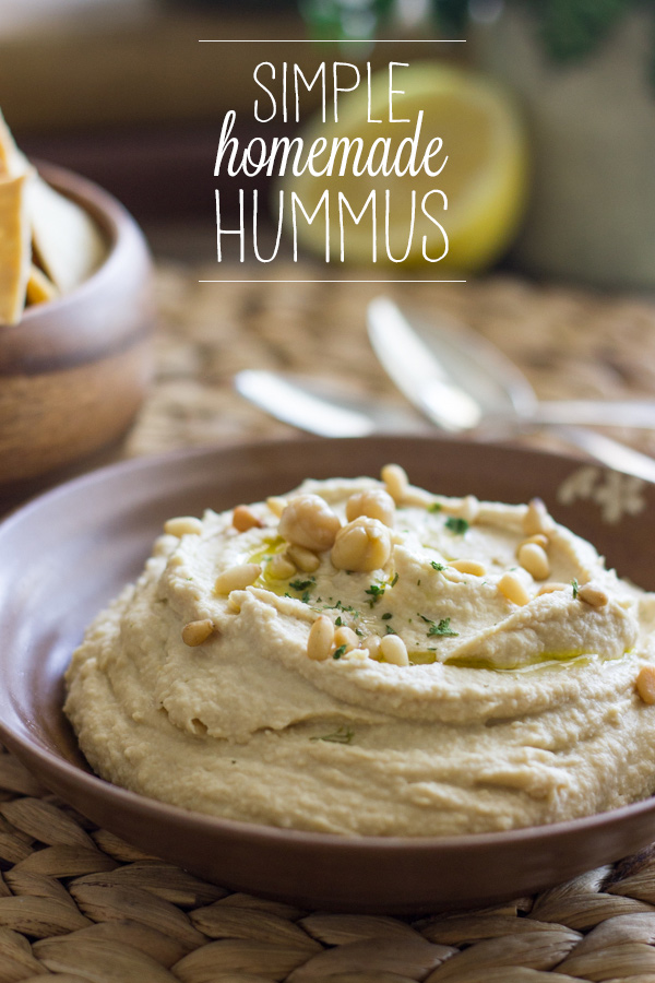 Simple Homemade Hummus in a bowl, topped with a drizzle of olive oil, dried parsley and pine nuts.