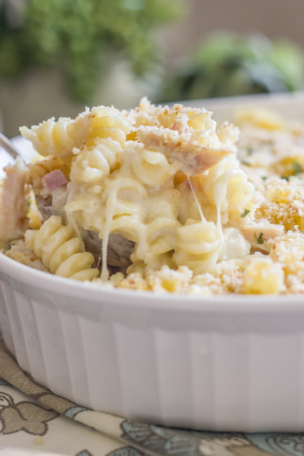 Chicken Cordon Bleu Pasta Bake in a baking dish with a serving spoon in it.  