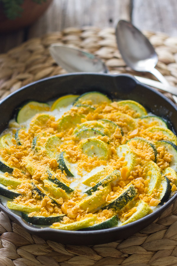 Zucchini and Yellow Squash Skillet Gratin in a cast iron skillet, with two spoons next to it.  