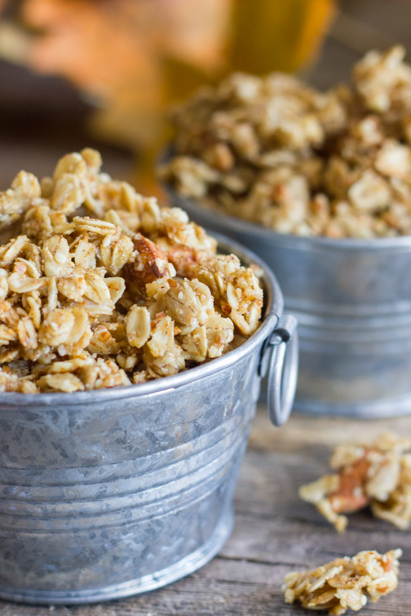 Pumpkin Pie Spice Coconut Oil Granola in two mini galvanized buckets, with some granola clusters next to the buckets.