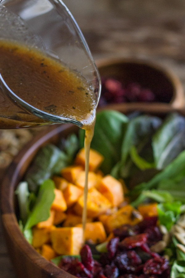 Salad dressing being poured over the Roasted Sweet Potato Salad.