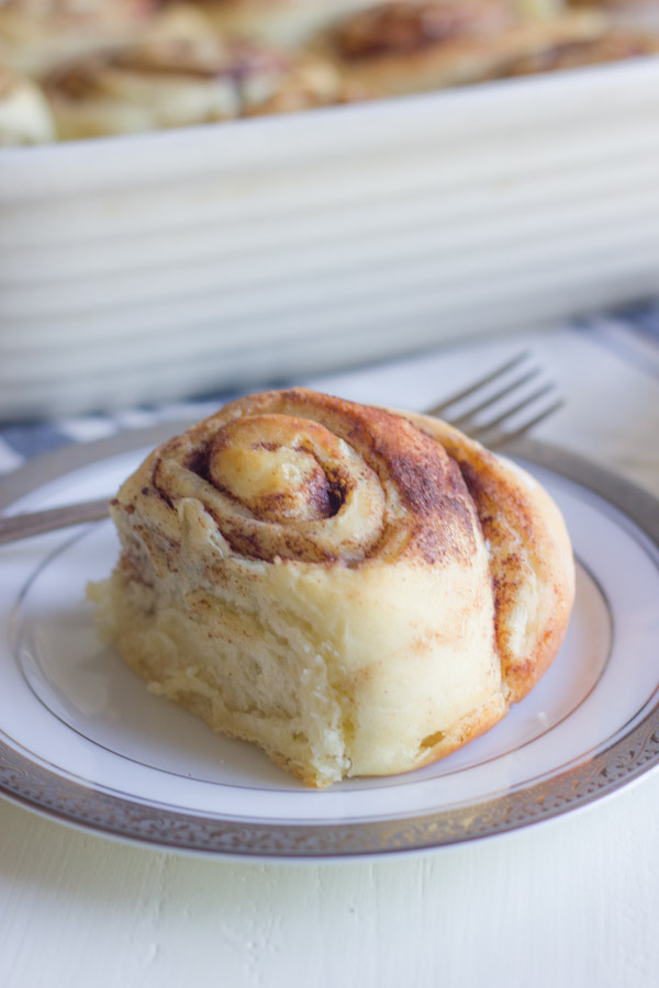 Overnight Cinnamon Roll on a plate with a fork.  
