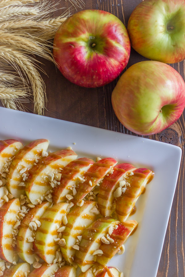Caramel Apple Slices on a serving platter, with whole apples next to it.  