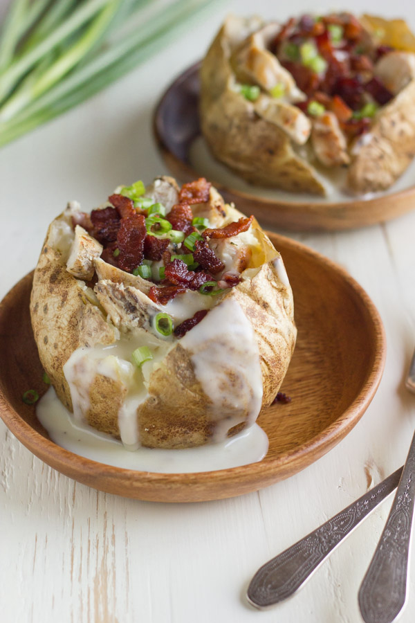 Loaded Chicken and Bacon Alfredo Potatoes on wood plates.  