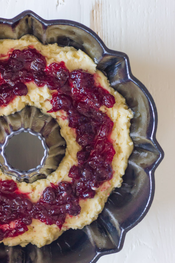 Half of the cake batter in the bottom of the pan, topped with the cranberry sauce.