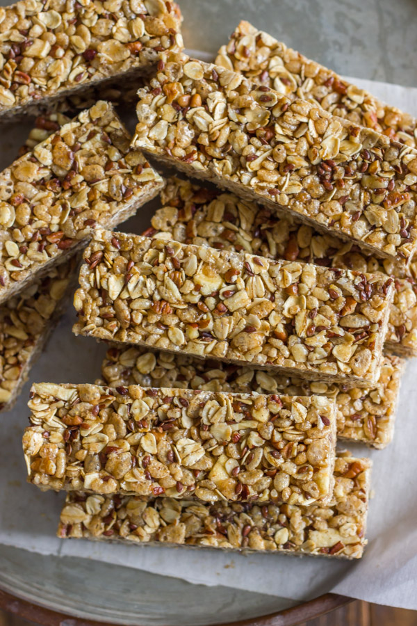 Healthy Chewy Apple Cinnamon Granola Bars stacked on a piece of parchment paper.  