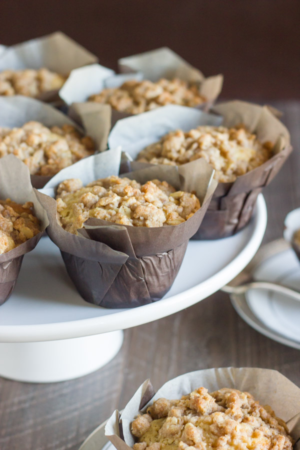 Healthier Cinnamon Oat Streusel Muffins in parchment paper muffin liners on a cake stand.  