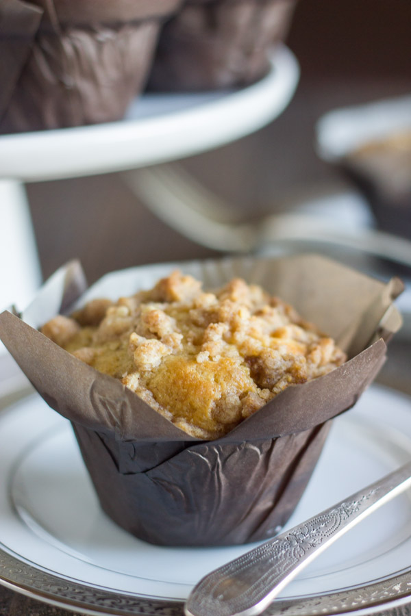 Healthier Cinnamon Oat Streusel Muffin in a parchment paper muffin liner on a plate.  