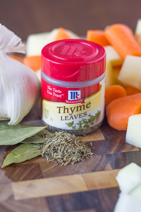 A spice container of McCormick Thyme Leaves on a cutting board with other ingredients for the Irish Beef Stew.
