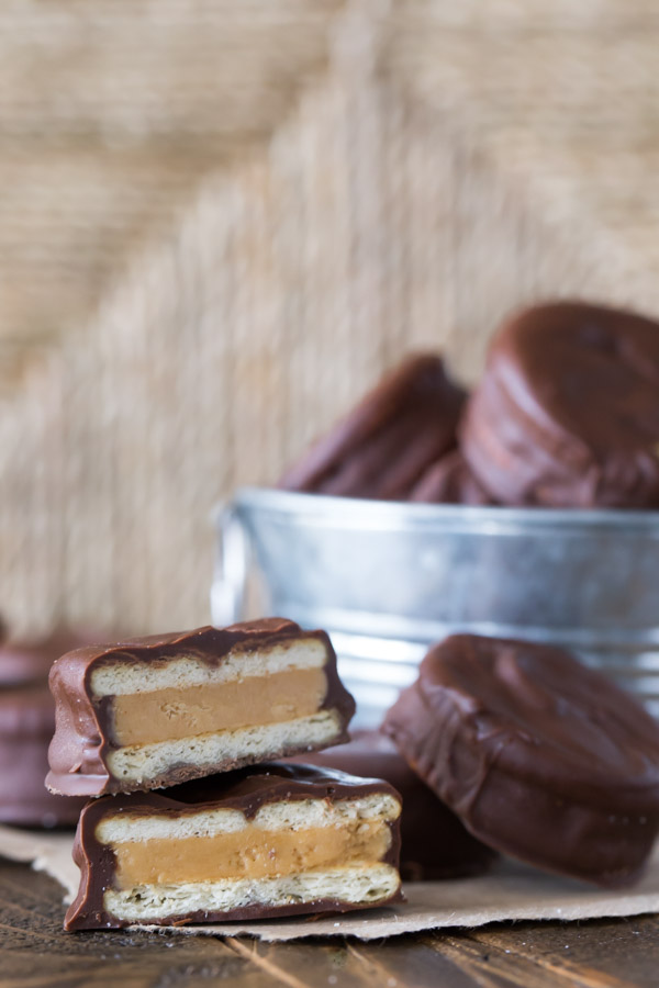 Peanut Butter Buckeye Cookie cut in half and stacked, with more cookies around it and in a small galvanized bucket in the background.  