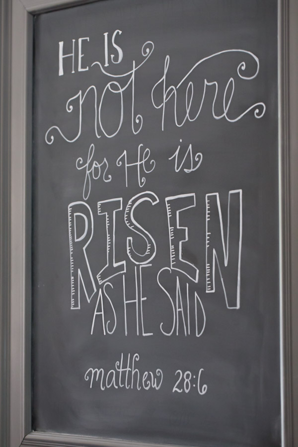 A chalk board that says He is not here for He is risen as He said - Matthew 28:6.  