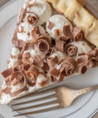 Homemade Chocolate Pudding Pie - Rich, creamy homemade chocolate pudding topped with whipped cream and piled with milk chocolate curls.