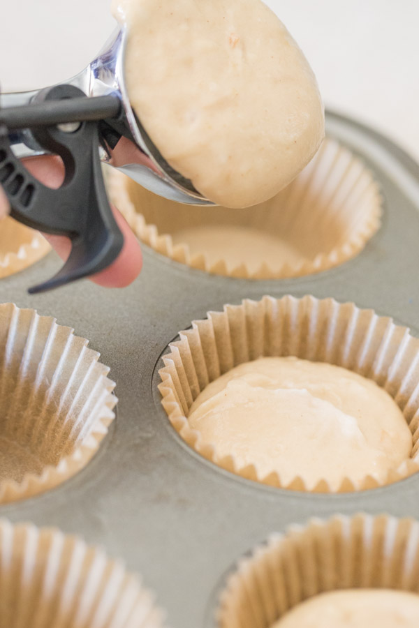 Apple Cupcake batter being scooped into the lined muffin pan.  
