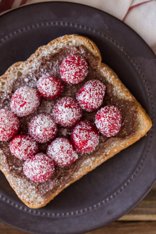 Chocolate Hazelnut Raspberry Toast sprinkled with powdered sugar on a plate.  
