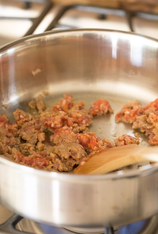 Sausage being browned in a large pan for the One Pot Fusilli With Tomato, Basil, and Mozzarella.
