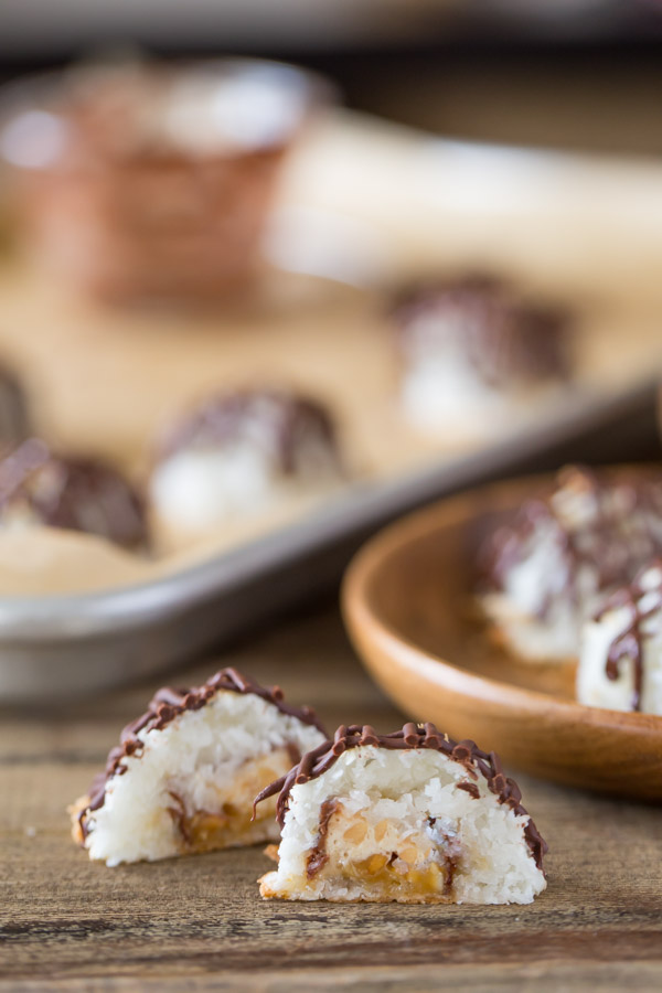 A Stuffed Chocolate Almond Macaroon that has been drizzled with chocolate and cut in half, showing the candy bar center. 
