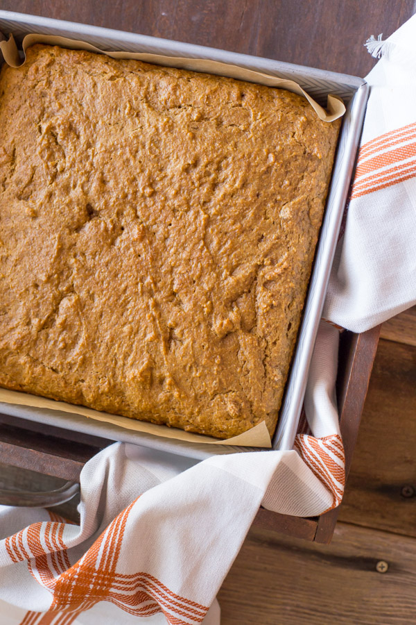 Healthier Pumpkin Spice Snack Cake in a parchment paper lined baking pan.  