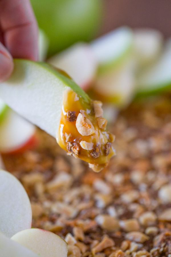 An apple slice that has been dipped into the Easy Caramel Apple Dip.  