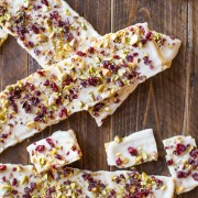 Cranberry Pistachio Butter Cracker Bark - A thin layer of white chocolate on a flaky buttery cracker with a sprinkle of dried cranberries and pistachios.