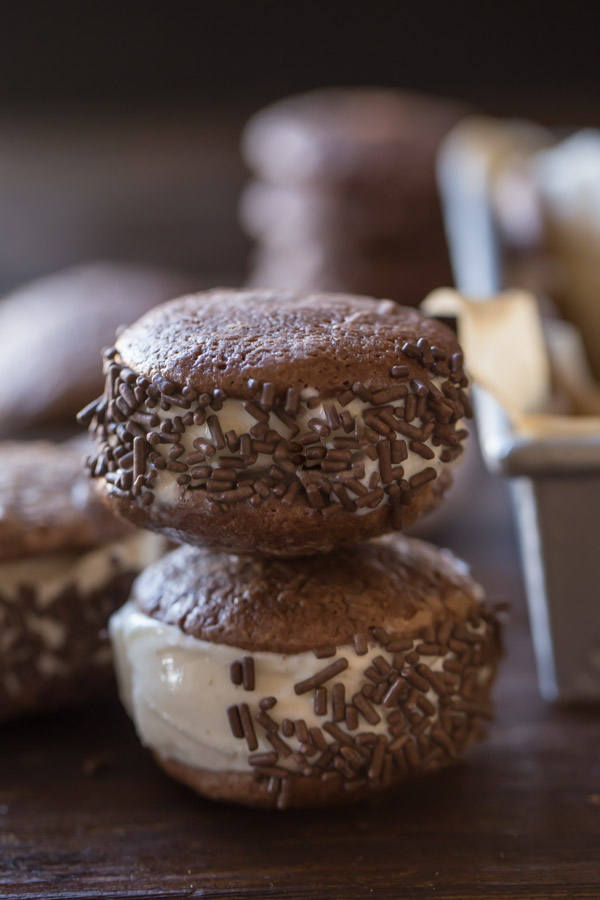 Two Brownie Cookie Ice Cream Sandwiches with chocolate sprinkles stacked.