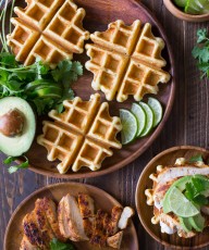 Green Chile Chicken Waffletada - A mini cornbread waffle served tostada style, topped with a green chile cream, grilled chicken, and avocado!
