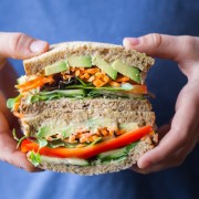 Power Veggie Sandwich - A colorful and power packed sandwich with a generous smear of roasted garlic hummus, and a pile of avocado, cucumber, red pepper, carrots and micro greens.