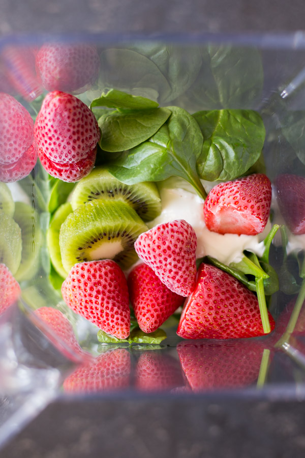 A blender with all the ingredients for the Strawberry Kiwi Protein Smoothie in it.  