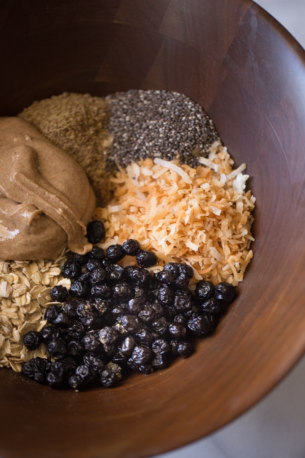 A wood bowl with all the ingredients for the Blueberry Muffin Energy Bites in it. 
