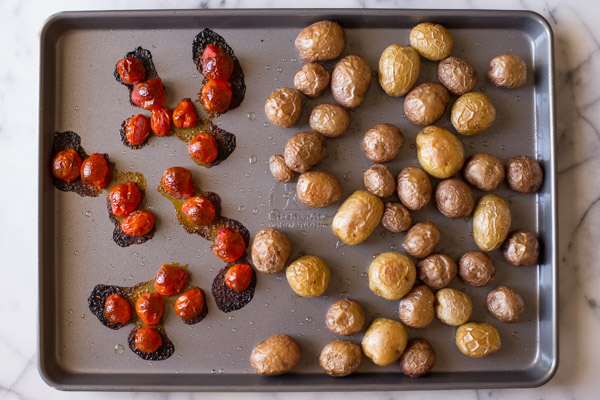 A baking sheet with the roasted tomatoes and potatoes.  