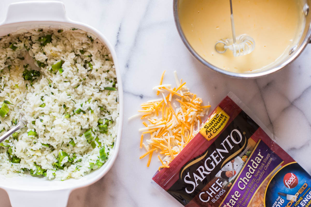 A baking dish with white rice and broccoli, sitting next to a package of Sargento® Chef Blends 4 State Cheddar and a bowl of the creamy cheddar cheese sauce for the Cheesy Broccoli Rice. 